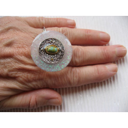 Large ring, silver metal charm and marbled stone, on a pearly white resin background