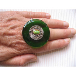 Very large ring, silver metal charm and marbled pearl, on an green resin background