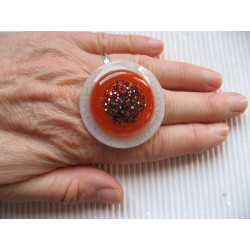 Very large ring, multicolored glitter cabochon, on an orange and white pearlescent resin background