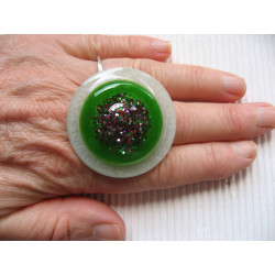 Very large ring, multicolored glitter cabochon, on an green and white pearlescent resin background